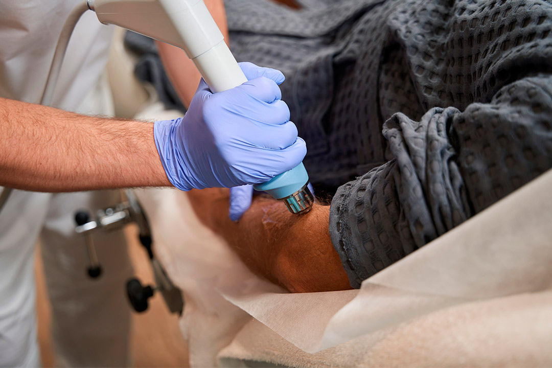 Individual getting an shockwave therapy in the arm for treatment of golf elbow pain.