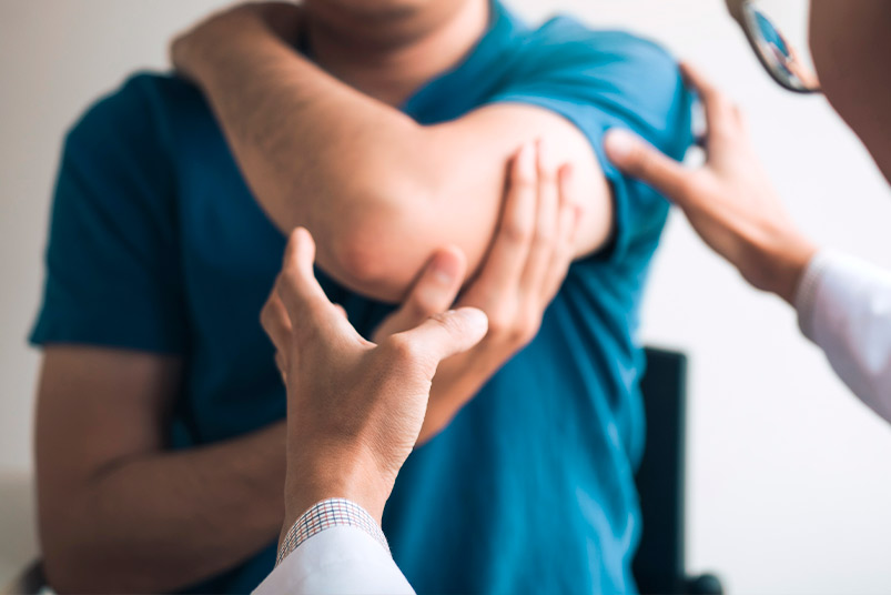 A physician assesses a patient's arm, referencing recent findings on shockwave therapy and PRP for improved recovery times.