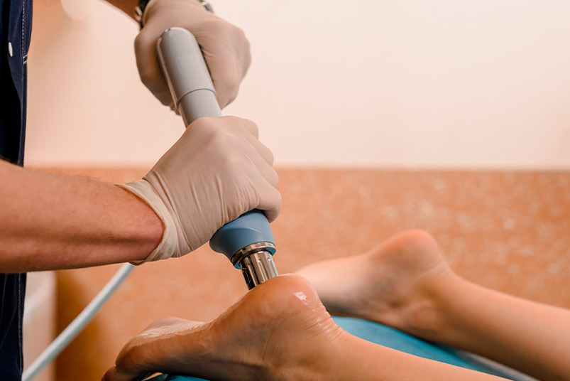 Individual enjoying an electric foot massager, highlighted in the Shockwave Machine: 2026 Buyers Guide for Clinics.