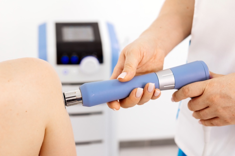 Effective Shockwave Therapy for full-body wellness. A young woman receiving treatment for pain relief and muscle recovery. Enhances overall health and promotes healing.